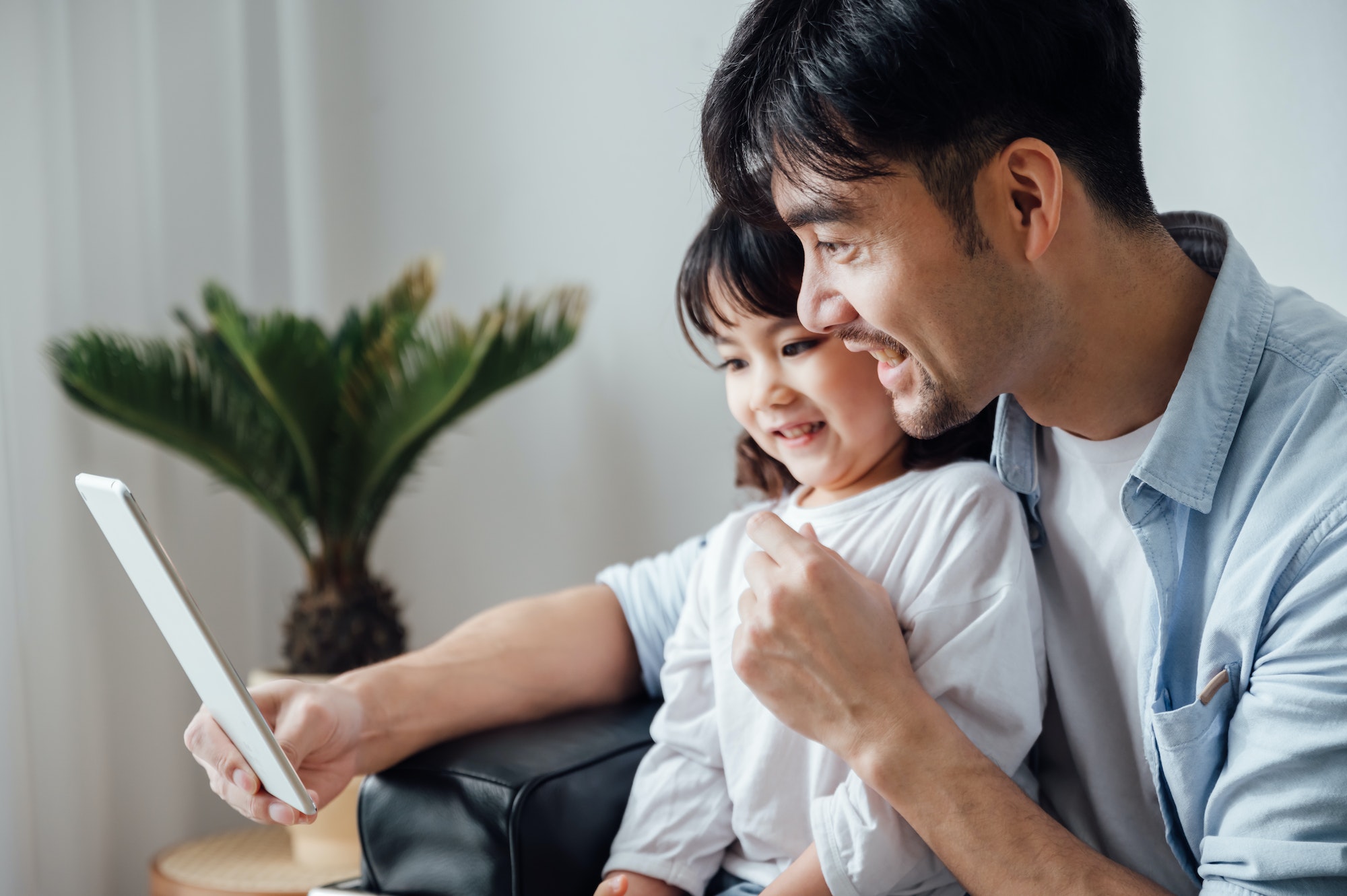 Father and daughter using ipad together at home